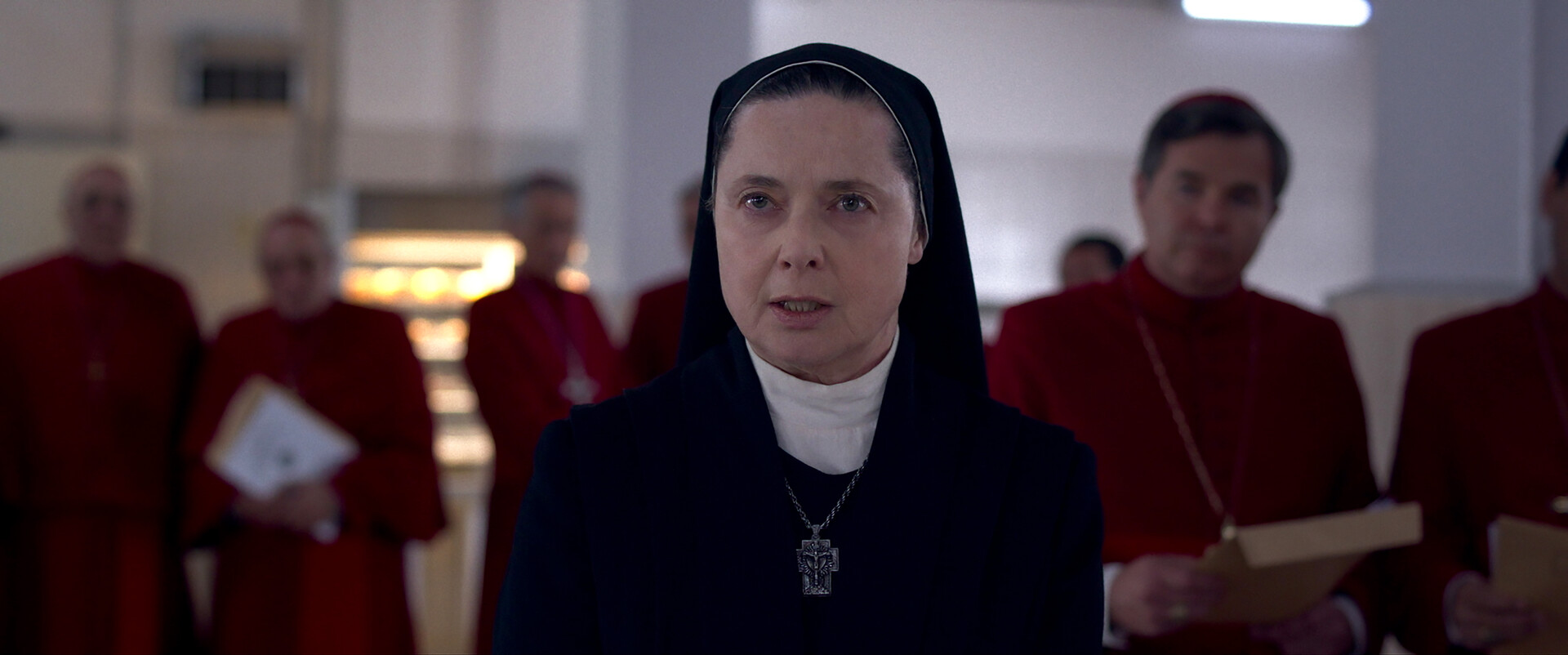 Actor Isabella Rossellini on set facing the camera with bishops in the background