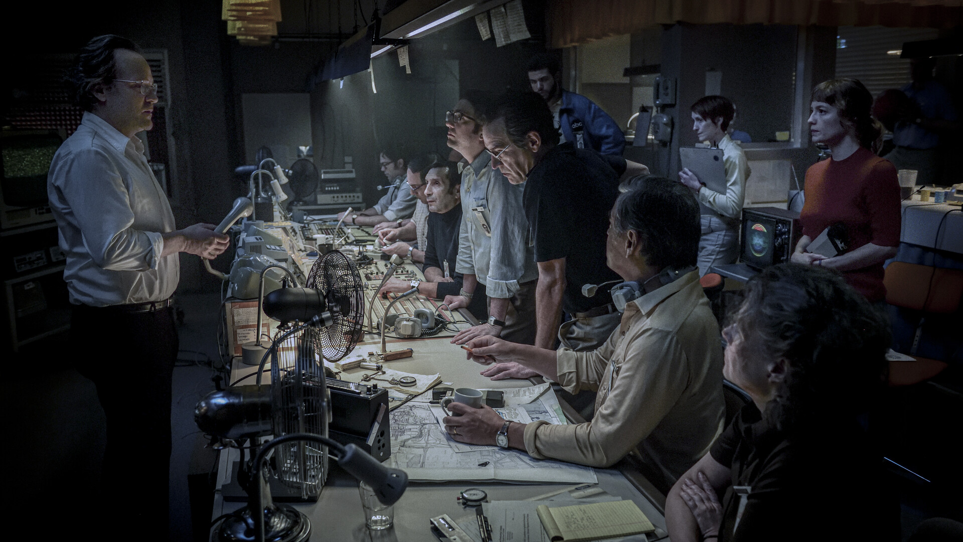 Peter Sarsgaard holding a telephone looking at the cast